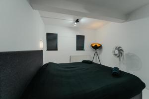 a bedroom with a black bed in a white room at Cube 21 in Mons