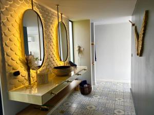 a bathroom with two mirrors on a yellow wall at La Font Ecolodge in Buenavista +65 photos