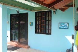 a house with blue walls and a glass door at Casitas del Sol in Ojochal +45 photos