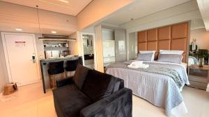 Un dormitorio con una cama y una silla y una cocina. en Tropical Executive Flat Suites 507 view, en Manaus 18 fotos más