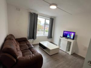a living room with a couch and a television at Bridge Hotel Apartments in Frodingham