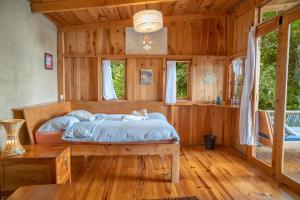 una camera da letto con un letto e un pavimento in legno di Venga Atitlan a San Marcos La Laguna