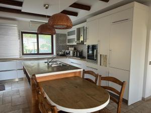 a kitchen with a wooden table with chairs and a sink at Villa Melandra in Engomi