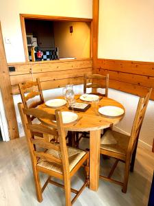 a wooden table with four chairs and a wooden table and chairsktop at Le Chamois 5E Balcon panoramique MontBlanc avec parking gratuit in Chamonix-Mont-Blanc