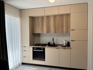 a kitchen with white cabinets and a stove top oven at Gate 12 in Otopeni