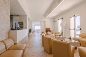 a waiting room with a row of chairs and tables at Hotel Peschici in Peschici