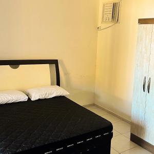 a bed with a black mattress in a room at Apartamento no Andar Inferior na Praia da Vila em Imbituba in Imbituba