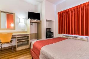 Una habitación de hotel con una cama con una cortina roja. en Motel 6 Fort Mill, SC - Charlotte, en Fort Mill