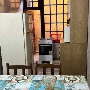 a kitchen with a table and a refrigerator at Apartamento no Andar Inferior na Praia da Vila em Imbituba in Imbituba