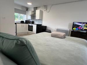 a bedroom with a large bed and a kitchen at Bridge Hotel Apartments in Frodingham