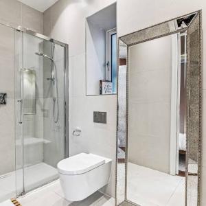 een witte badkamer met douche en toilet bij Bien sweet homes in Nairobi