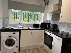 a kitchen with a sink and a washing machine at Bridge Hotel Apartments in Frodingham +22 photos