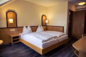 a bedroom with a large bed with white sheets at Hotel Cafe Kern in Großostheim +31 photos