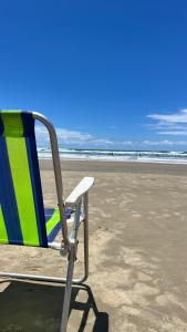 a beach chair sitting on the sand at the beach at Apartamento no Andar Inferior na Praia da Vila em Imbituba in Imbituba +3 photos