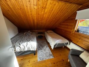 an attic room with two beds and a couch at Villa Vanttaja in Kuusamo