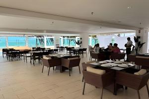 a restaurant with tables and chairs and people in the background at Cobertura em Hotel de Luxo na Beira Mar in Natal