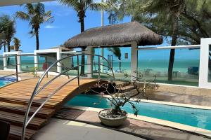 a wooden bridge over a swimming pool next to a resort at Cobertura em Hotel de Luxo na Beira Mar in Natal