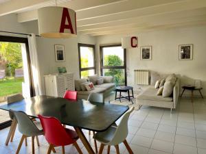 ein Wohnzimmer mit Tisch und Stühlen in der Unterkunft L'Abri du Rouget, 5 minutes à pied de la plage du Trez-hir, vacances en famille in Plougonvelin