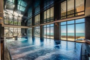 a large swimming pool with a view of the ocean at Baltic Infinity Resort&Spa Apartament Dworek in Międzyzdroje