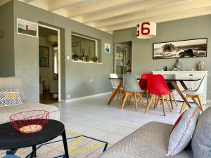 ein Wohnzimmer mit Tisch und Stühlen in der Unterkunft L'Abri du Rouget, 5 minutes à pied de la plage du Trez-hir, vacances en famille in Plougonvelin + 26 Fotos