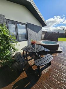 une terrasse avec une table et deux chaises et une baignoire dans l'établissement Comfort and Rest, à Sandgerði