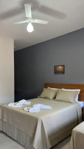 a bedroom with a bed with a ceiling fan at Castelo do Lago Hotel e Restaurante in Fama