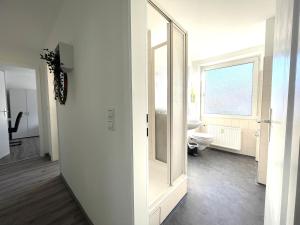 a white bathroom with a toilet and a window at Miracle 3 Betts Apart mit Parkplatz in Altomünster +1 photo