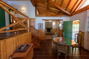 a living room with wooden walls and wooden stairs at Pousada Refúgio do Leão in Camanducaia