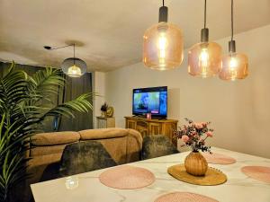 a living room with a table and a television at Chic 2-room apartment in the historic cathedral district in Augsburg
