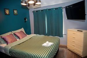 a bedroom with a bed with a green wall at 2BR Home in Manchester near Etihad Stadium with Parking in Manchester