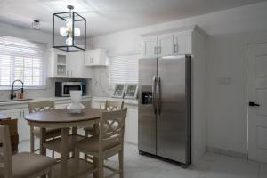 a kitchen with a table and a stainless steel refrigerator at Tuscany Sunville in Montego Bay