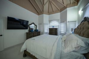 a bedroom with a bed and a flat screen tv at Tuscany Sunville in Montego Bay