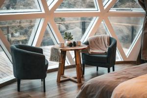a room with two chairs and a table in front of a window at Nawal Glamping - Domos in Trevelín +23 photos