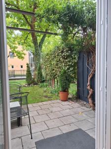 a patio with a table and a bench and trees at Modern 2-room apartment with terrace in Gauting in Gauting