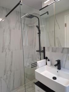 a white bathroom with a sink and a shower at Modern 2-room apartment with terrace in Gauting in Gauting +5 photos