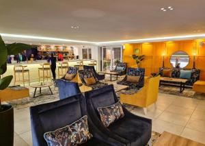 a living room with couches and chairs and a bar at Blue Marlin All-Inclusive Seascape by Dream Resorts in Scottburgh