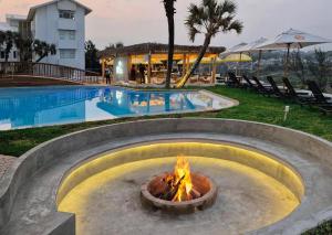 a fire pit in front of a swimming pool at Blue Marlin All-Inclusive Seascape by Dream Resorts in Scottburgh