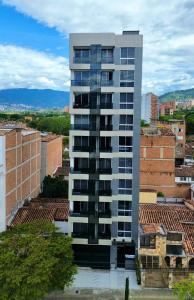 a tall white apartment building in a city at Torre Zurich Luxury in Medellín