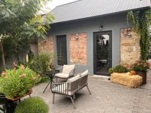 基希讷乌Tiny Barn House的庭院设有两把椅子和一张鲜花桌子