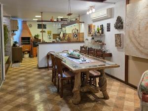 a kitchen with a wooden table and some chairs at Casa das Hortênsias in Teresópolis