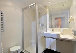 a white bathroom with a shower and a sink at Hotel TA Sololaki in Tbilisi City
