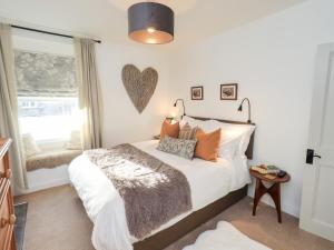 ein Schlafzimmer mit einem Bett mit einem Herz an der Wand in der Unterkunft Gosling Cottage in Kendal