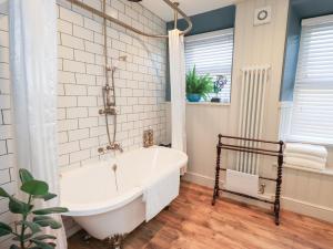ein Bad mit einer weißen Badewanne und einem Fenster in der Unterkunft Gosling Cottage in Kendal + 22 Fotos