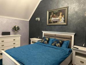 Un dormitorio con una cama azul y una pintura en la pared en Villa Contessa, en Piatra Neamţ 6 fotos más