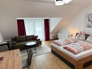 a living room with a bed and a couch at Liesingtal Deluxe Terrace Family Suite in Vorderlainsach
