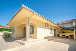 ein freistehendes Haus mit einer großen Terrasse in der Unterkunft Casa térrea com 03 quartos em Canto Grande in Canto Grande