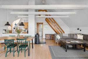 a living room with a couch and a table and chairs at 6843-Allinge-Lundegardsvej-16-B in Sandkås