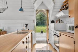 a kitchen with a sink and an open door at 6843-Allinge-Lundegardsvej-16-B in Sandkås +11 photos