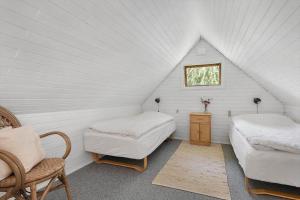 a attic room with two beds and a window at 6843-Allinge-Lundegardsvej-16-B in Sandkås