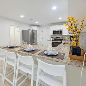 パナマ・シティ・ビーチにあるStunning 4BD Jacuzzi - 4 Min To Beach Panama Cityのキッチン(椅子とテーブル、ワイングラス付) +12枚の写真